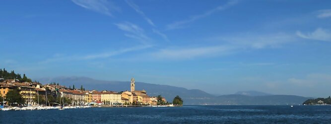 Trip Niederösterreich beliebte Urlaubsziele am Gardasee -  Mit einer Fläche von 370 km² ist der Gardasee der größte See Italiens. Es liegt am Fuße der Alpen und erstreckt sich über drei Staaten: Lombardei, Venetien und Trentino. Die maximale Tiefe des Sees beträgt 346 m, er hat eine längliche Form und sein nördliches Ende ist sehr schmal. Dort ist der See von den Bergen der Gruppo di Baldo umgeben. Du trittst aus deinem gemütlichen Hotelzimmer und es begrüßt dich die warme italienische Sonne. Du blickst auf den atemberaubenden Gardasee, der in zahlreichen Blautönen schimmert - von tiefem Dunkelblau bis zu funkelndem Türkis. Majestätische Berge umgeben dich, während die Brise sanft deine Haut streichelt und der Duft von blühenden Zitronenbäumen deine Nase kitzelt. Du schlenderst die malerischen, engen Gassen entlang, vorbei an farbenfrohen, blumengeschmückten Häusern. Vereinzelt unterbricht das fröhliche Lachen der Einheimischen die friedvolle Stille. Du fühlst dich wie in einem Traum, der nicht enden will. Jeder Schritt führt dich zu neuen Entdeckungen und Abenteuern. Du probierst die köstliche italienische Küche mit ihren frischen Zutaten und verführerischen Aromen. Die Sonne geht langsam unter und taucht den Himmel in ein leuchtendes Orange-rot - ein spektakulärer Anblick.